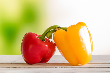 Image showing Red and yellow pepper on a wooden table