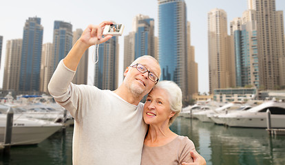 Image showing senior couple taking selfie with camera at harbor