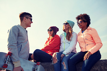 Image showing happy teenage friends with skateboard on street