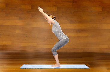 Image showing woman making yoga in chair pose on mat