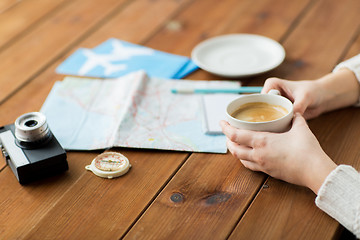 Image showing close up of hands with coffee cup and travel stuff