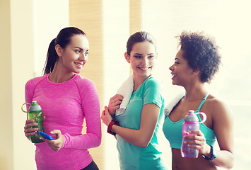 Image showing happy women with bottles of water in gym