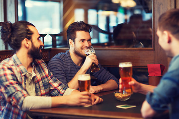 Image showing happy male friends drinking beer at bar or pub