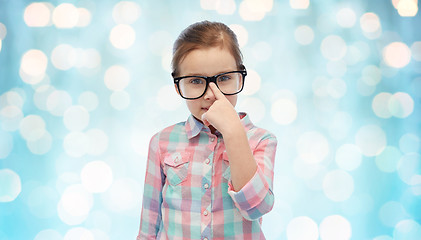 Image showing happy little girl in eyeglasses over blue lights