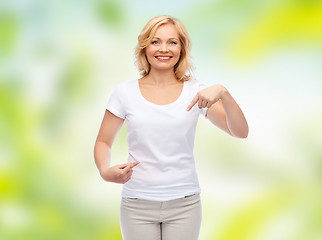 Image showing smiling woman in white t-shirt pointing to herself