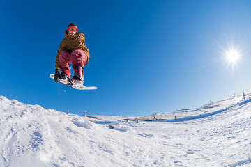 Image showing Snowboarder jumping against blue sky