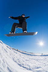 Image showing Snowboarder jumping against blue sky