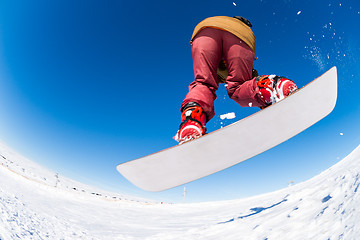 Image showing Snowboarder jumping against blue sky