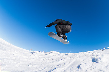 Image showing Snowboarder jumping against blue sky