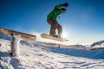 Image showing Snowboarder jumping against blue sky