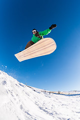 Image showing Snowboarder jumping against blue sky