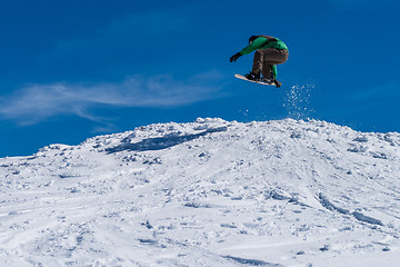 Image showing Snowboarder jumping against blue sky