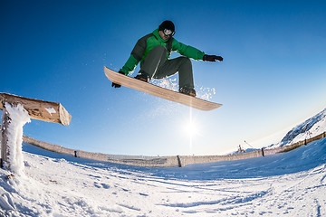 Image showing Snowboarder jumping against blue sky