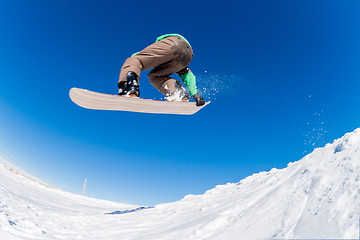 Image showing Snowboarder jumping against blue sky