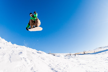 Image showing Snowboarder jumping against blue sky