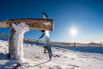 Image showing Snowboard leaning on a wood rail