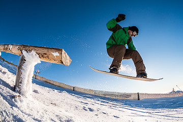 Image showing Snowboarder jumping against blue sky