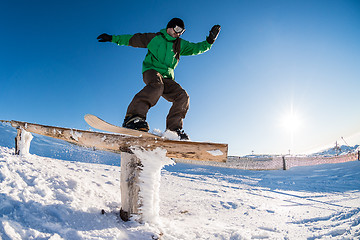 Image showing Snowboarder sliding on a rail