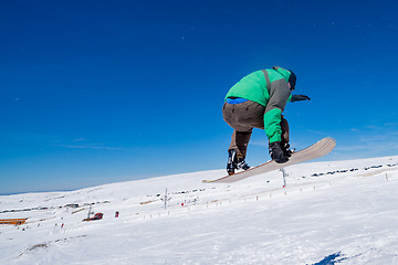 Image showing Snowboarder jumping against blue sky