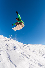 Image showing Snowboarder jumping against blue sky