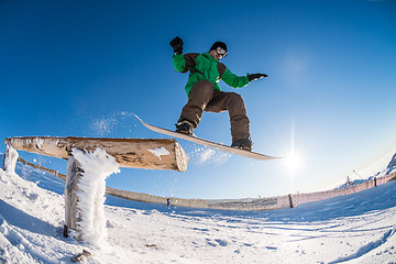 Image showing Snowboarder jumping against blue sky