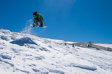 Image showing Snowboarder jumping against blue sky