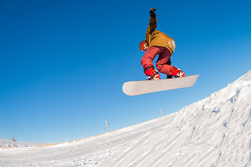 Image showing Snowboarder jumping against blue sky