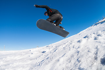 Image showing Snowboarder jumping against blue sky