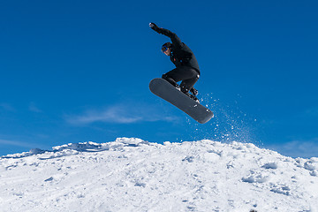 Image showing Snowboarder jumping against blue sky