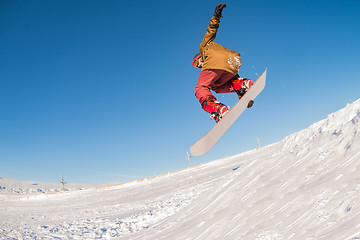 Image showing Snowboarder jumping against blue sky