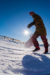 Image showing Snowboarder walking against blue sky