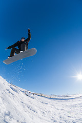 Image showing Snowboarder jumping against blue sky