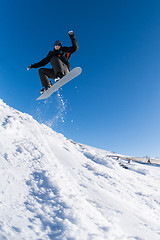 Image showing Snowboarder jumping against blue sky