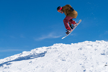 Image showing Snowboarder jumping against blue sky