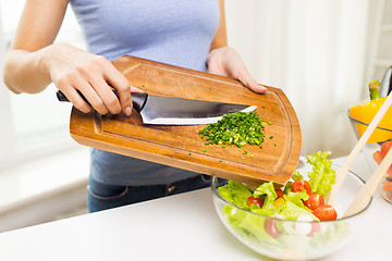 Image showing close up of woman with chopped onion cooking salad