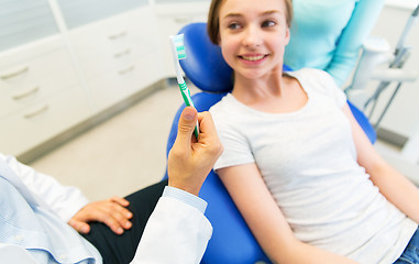 Image showing close up of dentist hand with toothbrush and girl