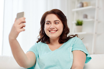 Image showing happy plus size woman with smartphone at home