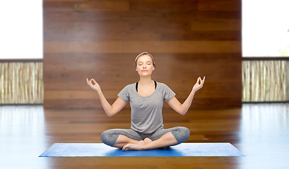 Image showing woman making yoga meditation in lotus pose on mat