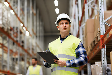 Image showing man with clipboard in safety vest at warehouse