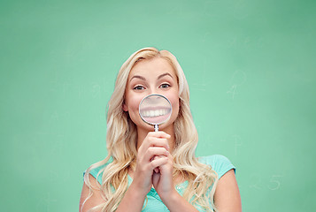 Image showing happy young woman with magnifying glass