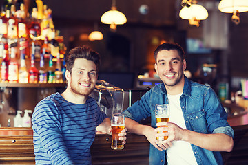 Image showing happy male friends drinking beer at bar or pub