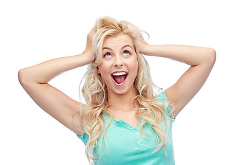 Image showing smiling young woman holding to her head or hair