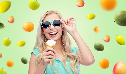 Image showing happy young woman in sunglasses eating ice cream