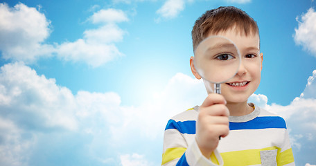 Image showing happy little boy looking through magnifying glass