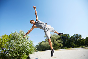 Image showing sporty young man jumping in summer park