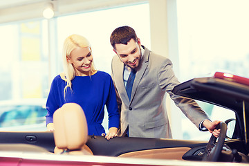 Image showing happy couple buying car in auto show or salon