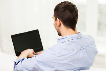 Image showing close up of man typing on laptop computer at home