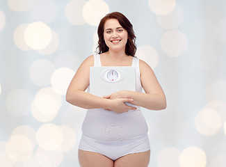 Image showing happy young plus size woman holding scales