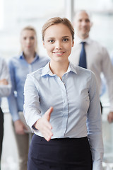 Image showing smiling businesswoman making handshake in office