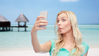 Image showing funny young woman taking selfie with smartphone